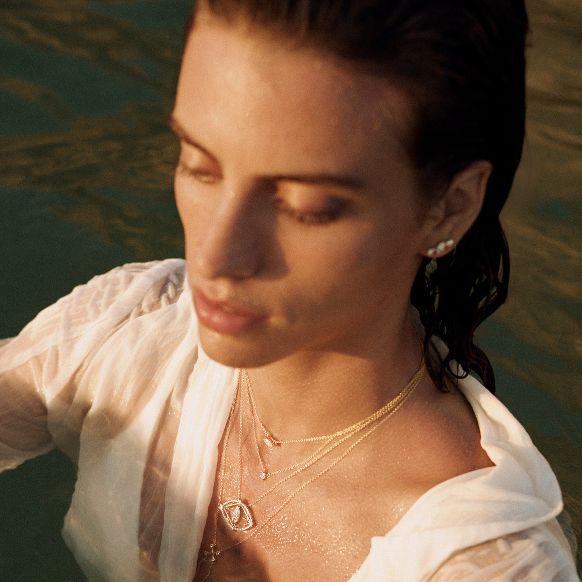 Woman in a white shirt with 14k yellow gold evil eye necklace